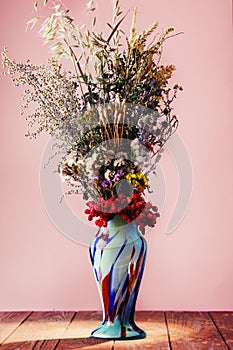 Bouquet of field dried flowers in vintage blue vase