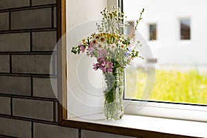 Bouquet of flowers in a vase on the window