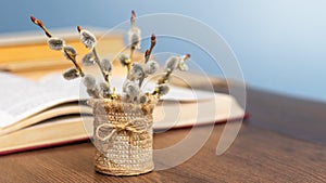 Bouquet of flowering willow branches near an open book