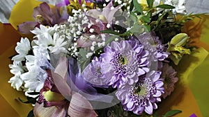 Bouquet of flowers as a gift. Floral background. Purple, white and blue flowers close-up. Chamomile, aster, iris