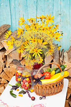 Bouquet of flowers and basket with autumn crop of seasonal vegetables