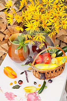 Bouquet of flowers and basket with autumn crop of seasonal vegetables