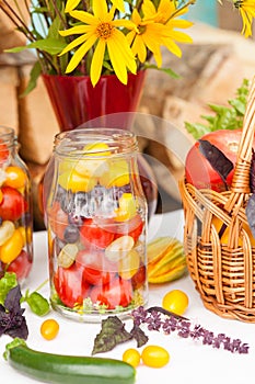 Bouquet of flowers and basket with autumn crop of seasonal vegetables