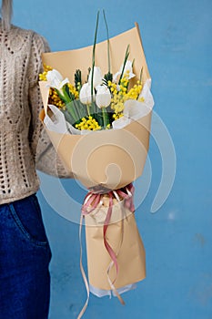 Bouquet of flowers in beige package in hands