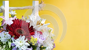 A bouquet of flowers from gerberas, chrysanthemums, lilies. Close-up. Macro shooting. Bright yellow background.