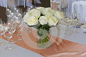 Bouquet of flowers in a glass vase on the festive table in the restaurant