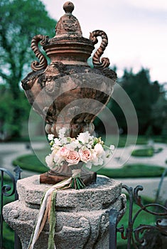 Bouquet of flowers lies near an antique vase in the garden. Lake Como, Italy