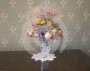 A bouquet of flowers in an old crystal vase