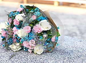 Bouquet of flowers, pink carnation and white rose decorate with blue cutter flower and purple static flower for commencement day.