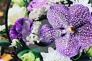 A bouquet of flowers in purple tones with a tiger orchid in the center.