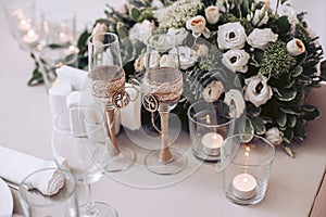 Bouquet of flowers from roses with glasses and candles on the wedding table