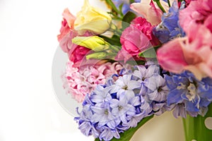 Bouquet of flowers on a shelf by the wall. Flowering branches in a bucket with a pea pattern
