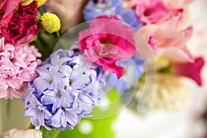 Bouquet of flowers on a shelf by the wall. Flowering branches in a bucket with a pea pattern