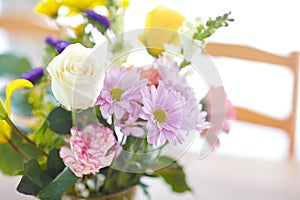 Bouquet, flowers and table with mothers day, celebration and anniversary gift in a home. Vase, rose and daisy plant in a