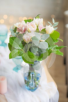 Bouquet of flowers in vase on the table with candles