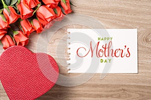 Bouquet of fresh pink red roses with gift on wooden background. Floral romantic arrangement with card text Happy Mother's Day