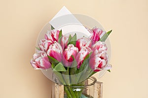 Bouquet of fresh red-white tulips with a card for your text. Gift for romantic date. Tender spring flowers. Bunch of tulips for