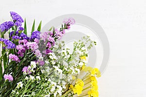 Bouquet fresh spring colorful flower with yellow mum , marguerite purple and white cutter flowers on white wooden