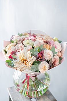 Bouquet of fresh spring flowers on gray wall background. Floral bunch in glass vase. flower shop, florist work