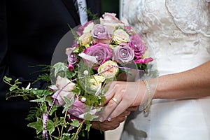 Bouquet and gold ring on hand photo