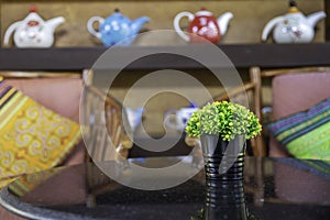 Bouquet of green flowers in a black vase on table in living room