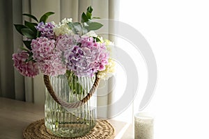 Bouquet of hydrangea flowers on table near window, space for text. Interior design