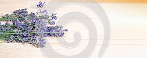 A bouquet of lavender flowers, shot from above on a rustic wooden background with a place for text, banner