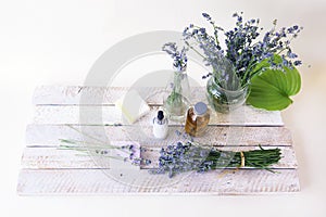 Bouquet of lavender flowers, soap, cream and aromatic oil on the table