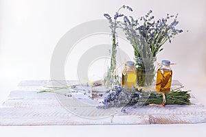 Bouquet of lavender flowers, soap, cream and aromatic oil on the table, light background, spa, natural cosmetics