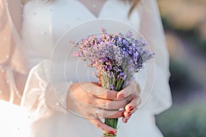 A bouquet of lavender in the hands of the bride. Bouquet of lavender in the throes of a woman