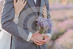 A bouquet of lavender in the hands of the groom. A bouquet of lavender in the throes of a man