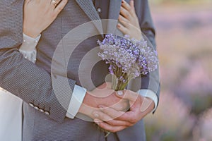 A bouquet of lavender in the hands of the groom. A bouquet of lavender in the throes of a man