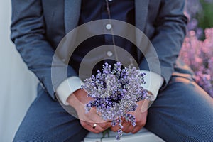 A bouquet of lavender in the hands of the groom. A bouquet of lavender in the throes of a man