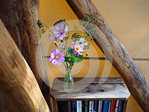 Bouquet of lilac flowers on a bookshelf
