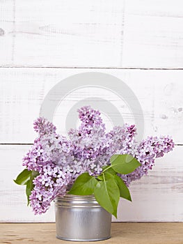 Bouquet of lilac flowers on white wooden background