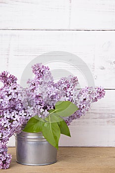 Bouquet of lilac flowers on white wooden background