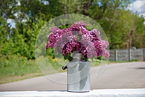 bouquet of lilac stands on the street in the yard on a table
