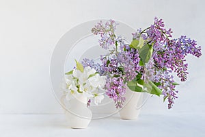 Bouquet of lilac in a vase on a light background