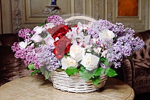 Bouquet of lilacs and red peonies on marble table