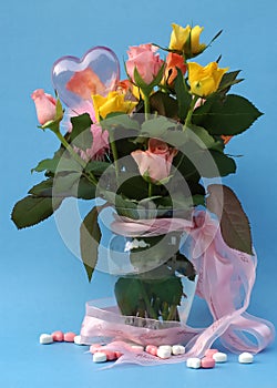 Bouquet of multicolored roses in a vase with pink ribbon