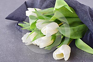 Bouquet of multicolored tulips on a grey cloth. Spring flowers. Romance