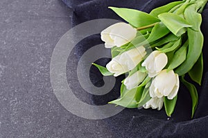 Bouquet of multicolored tulips on a grey cloth. Spring flowers. Romance