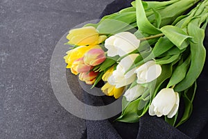 Bouquet of multicolored tulips on a grey cloth. Spring flowers. Romance