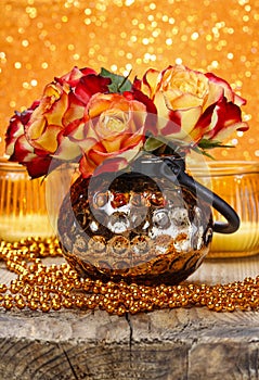 Bouquet of orange and red roses in golden vase