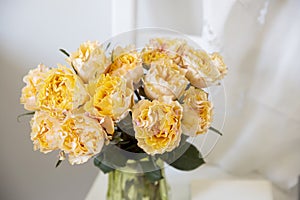 Bouquet of orange roses Candlelight on the white wooden chair next to white wall
