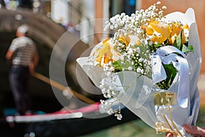 A bouquet of a orange roses at gondolier background in tne Venice, Italy