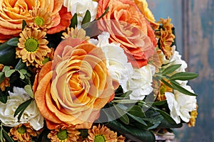 Bouquet of orange roses and ivory carnation flowers