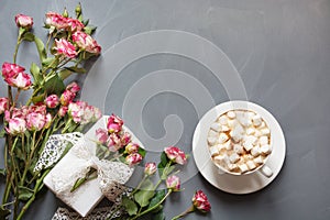 Bouquet of pink bush roses, female gift and cup of coffee on shabby chic background, top view point. Copy space. Mother`s day bac