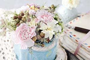 Bouquet of pink carnations and yellow Kalanchoe blossfeldiana flowers in blue ceramic vase