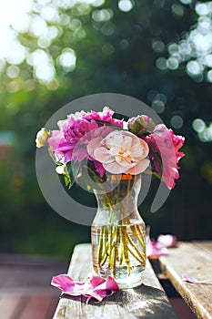 Bouquet of pink and cream peonies in a vase.
